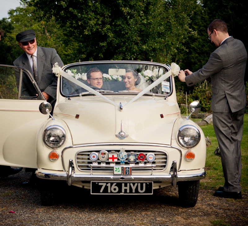 Vintage Morris Minor departs Kent wedding with the Bride and Groom